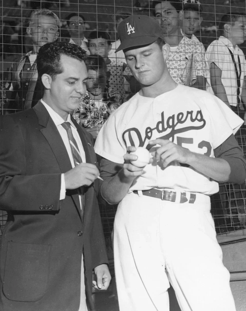 Spanish-language play-by-play announcer Rene Cardenas (left), of the radio station KWKW, listens as baseball player Don Drysdale, of the <a class=